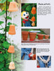 Create a fun autumn garden project for kids with step-by-step photos from *Kinder Gardens: Autumn Fun* by Schiffer Publishing, Ltd.—learn to make stacked clay pots hanging on a string, perfect for outdoor activities among leafy green plants.