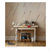In "Behind the Easel" by Schiffer Publishing, Ltd., a striking scene shows arrows shattering plates midair over a table of dishes, fruit, and teapot, while objects like a shoe and clock echo contemporary representational art.