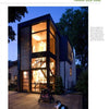 A modern two-story home with floor-to-ceiling windows and eco-renovation details, inspired by "Eco-House Renovations" from Schiffer Publishing, Ltd.; warmly lit at dusk with a dog on the wooden patio and trees in the background.