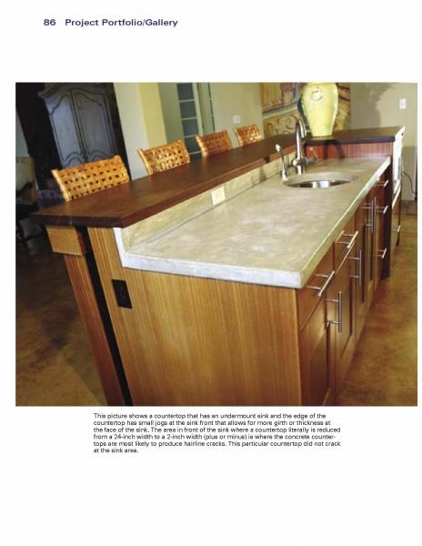 A kitchen island with Schiffer Publishing, Ltd.’s Cast-in-Place Concrete Countertops features an undermount sink, dark wood cabinets, and wicker-backed chairs. A large vase sits on the counter, with a dining area visible in the background.