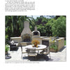 Relax or dine in a cozy patio with a stone fireplace and wood-fired oven, surrounded by greenery—perfect for testing gourmet recipes from The Ultimate Wood-Fired Oven Book by Schiffer Publishing, Ltd. Metal chairs and table complete the inviting scene.