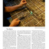 Practicing precise metalworking, a person uses a handheld torch to solder thin metal rods in a grid, as featured in "A Universe of Metal Sculpture" by Schiffer Publishing, Ltd., creating intricate sculpture techniques in a well-lit workspace.