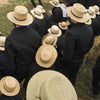Seen from above, people and children in black clothing and straw hats sit on hay bales, reflecting Amish life in Lancaster County—featured on the "Faces of Lancaster County Postcards" by Schiffer Publishing, Ltd.