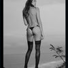 Paradise in Brazil, from Schiffer Publishing, Ltd., features a black-and-white image by a Brazilian photographer of a woman in black lingerie bottoms and stockings, framed by a tropical ocean and sky backdrop.