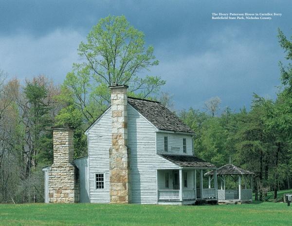 Experience the charm of rural mountain retreats with "West Virginia" by Schiffer Publishing, Ltd.—a scenic photography collection featuring a historic white wooden house with stone chimneys, a front porch, and a lush green lawn under cloudy skies.