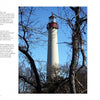 The Cape May Lighthouse from Schiffer Publishing, Ltd. stands tall with a red top above leafless trees and dark branches, set against a clear blue sky—a vivid tribute to lighthouse history.