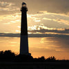 Barnegat Lighthouse Perspectives by Schiffer Publishing, Ltd. captures Barnegat Lighthouse rising against a golden sunset at Long Beach Island, with birds in flight and trees framing the Atlantic Coast in the background.