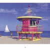 South Beach Lifeguard Stations by Schiffer Publishing, Ltd. features a vivid pink and yellow lifeguard stand on sandy Miami Beach near the ocean, with a sailboat on the water and a person walking under a blue sky.