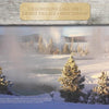 Snow-covered pines surround a steaming hot spring in Yellowstone National Park by Schiffer Publishing, Ltd., with geysers, mountains, and forest in the background beneath a partly cloudy sky.