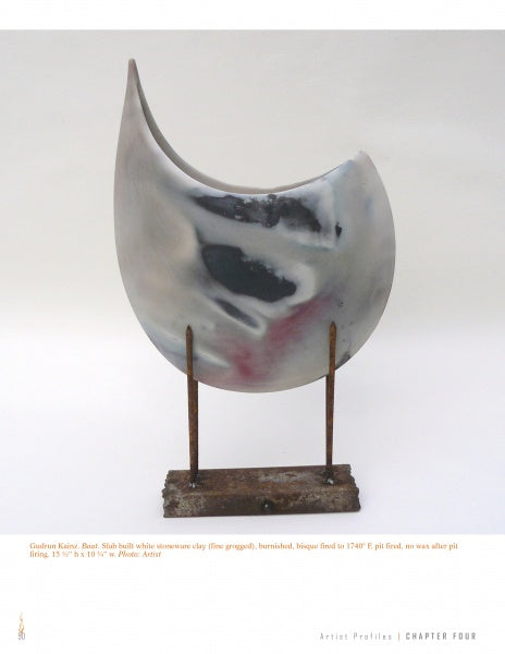 The Pit Firing Ceramics sculpture from Schiffer Publishing, Ltd. features a curved, crescent-shaped form with a marbled white, black, and pink finish on an upright rusted metal base supported by two vertical rods.