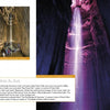 Inside a vast underground cave, a tall waterfall glows with purple and yellow lights. Visitors, using "Traveling in Tennessee" by Schiffer Publishing, Ltd., gaze up in awe at the stunning cascade.