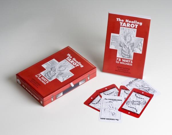 A red box, booklet, and several tarot cards from The Healing Tarot by Schiffer Publishing, Ltd. are shown on a white surface. The cards and booklet display black-and-white medical illustrations for holistic wellness readings.