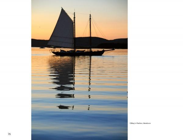 A sailboat glides on calm water against a sunset in "Maine" by Schiffer Publishing, Ltd., capturing the serene reflections and scenic beauty of classic Maine landscapes.