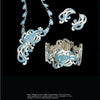 The Margot Van Voorhies set by Schiffer Publishing, Ltd. features mid-century-inspired blue and white chrysanthemum designs on a necklace, bracelet, ring, and earrings, all elegantly displayed on a black background.