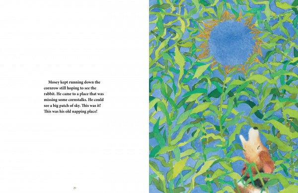 A storybook spread from "Mosey's Field" by Schiffer Publishing, Ltd.: left page features text; right page shows a small brown animal in a rural landscape, gazing up at a large blue sunflower among tall green leaves.