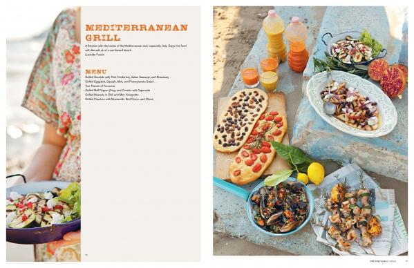 An outdoor spread of Mediterranean dishes features salads, grilled vegetables, flatbread, clams, and juice. Someone holds salad as the left shows "Grill Skills: Professional Tips for the Perfect Barbeque" by Schiffer Publishing, Ltd. with grilling tips.