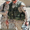 Two soldiers in desert camo stand outdoors. A U.S. Marine with sunglasses and helmet holds a rifle; military knives, featured in "Modern Knives in Combat" by Schiffer Publishing, Ltd., are attached to his tactical vest. Sandy background.