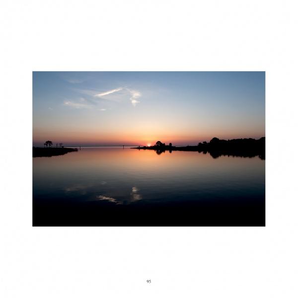 Experience iconic Maryland landscapes with "Maryland Landscapes" by Schiffer Publishing, Ltd.—featuring serene sunsets over Chesapeake Bay, silhouetted trees on the horizon, and soft sky reflections.