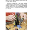 A person sharpens a large knife using Schiffer Publishing, Ltd.'s "Knife Sharpening Made Easy" guide; arrows highlight sharpening steps, with a stone and honing tools visible on the table.