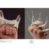 In On Body and Soul by Schiffer Publishing, Ltd., two fists display distinctive jewelry: the left wears a clear quartz crystal knuckleduster ring, while the right features a spiked metal ring.