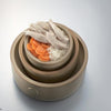 Cooking for Dogs by Schiffer Publishing, Ltd. features recipes like a layered clay pot with cooked chicken, white rice, and carrots—a great homemade dog treat to boost your dog's nutrition.