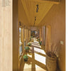 A sunlit hallway with wood floors and potted plants captures the sustainable home design featured in "Eco-House Renovations" by Schiffer Publishing, Ltd., as natural light and eco-friendly décor create a warm, inviting atmosphere.