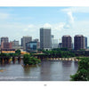 James River Reflections" by Schiffer Publishing, Ltd. captures downtown Richmond’s skyline—tall office towers and historic brick buildings viewed across the James River with trees, water, and a partly cloudy sky—perfect for Virginia photography lovers.