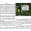 A historic marker stands on a grassy lawn near trees and a road, evoking scenes from "Greetings from Rutland, VT" by Schiffer Publishing, Ltd., with a building partially visible in the background.
