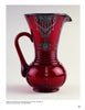 A striking vintage piece from Mauzy's Rare, Unusual, & Unique Depression Glass by Schiffer Publishing: a tall, deep red glass pitcher with ornate handle and silver overlay, beautifully displayed against a plain white background.