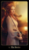 A woman in a flowing dress stands by a tree at sunset, gripping a sword, her determined expression evoking The Chronicles of Destiny Fortune Cards by Schiffer Publishing, Ltd. “4. The Heroine” is inscribed at the bottom of the image.