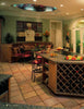 Great Kitchens by Schiffer Publishing, Ltd. showcases a roomy custom kitchen with a large island featuring a wine rack, stools, tiled floors, chef mural, decorative plants, and French doors that brighten the space with natural light.