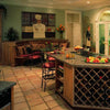 Great Kitchens by Schiffer Publishing, Ltd. showcases a roomy custom kitchen with a large island featuring a wine rack, stools, tiled floors, chef mural, decorative plants, and French doors that brighten the space with natural light.