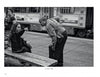 Captured in striking black and white, “Boston Below” by Schiffer Publishing, Ltd. reveals daily life on the MBTA: a woman sits on a bench, pointing assertively as a man leans in to listen, with city bustle in the background.