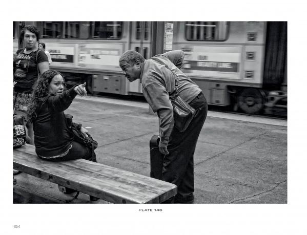 Captured in striking black and white, “Boston Below” by Schiffer Publishing, Ltd. reveals daily life on the MBTA: a woman sits on a bench, pointing assertively as a man leans in to listen, with city bustle in the background.