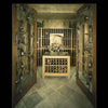 Wine Cellar Design by Schiffer Publishing, Ltd. features glass doors, metal vine accents, a central wooden wine rack, wall shelves, tiled floors, and warm lighting to elevate any luxury home's ambiance.