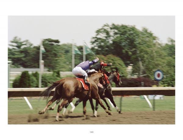 Two jockeys race thoroughbreds at full speed on a dirt track with trees and a circular sign in the background, capturing the excitement of Horse Racing by Schiffer Publishing, Ltd.—perfect for horse racing photography fans.