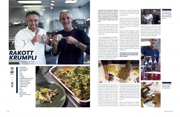 Two smiling men hold food containers in a kitchen. The left page displays a baked dish, while the right features cooking and wine as people prepare Rakott Krumpli, from The Athlete's Cookbook by Schiffer Publishing, Ltd.
