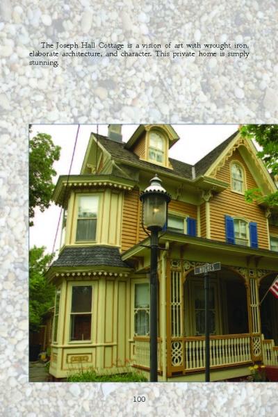 A charming Victorian cottage with ornate trim and a two-story bay window, often seen on Cape May Walking Tours by Schiffer Publishing, Ltd., stands behind a streetlamp and green trees on a bright day.