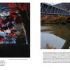 A vibrant, close-up of red autumn leaves and the Hudson River flowing under a steel bridge, with New York’s fall foliage reflected in the water—Schiffer Publishing, Ltd.'s "Hudson Valley Reflections" captures the perfect travel guide scene.