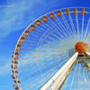 The cover of "Wildwood Moments" from Schiffer Publishing, Ltd. features a large Ferris wheel with red gondolas soaring above the boardwalk against a vivid blue sky, creating a vibrant and striking scene.