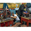Two factory workers repair machine parts at cluttered benches, echoing the behind-the-scenes work that keeps Boston’s MBTA running—just like the stories shared in "Boston Below" by Schiffer Publishing, Ltd.