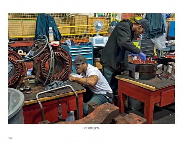 Two factory workers repair machine parts at cluttered benches, echoing the behind-the-scenes work that keeps Boston’s MBTA running—just like the stories shared in "Boston Below" by Schiffer Publishing, Ltd.
