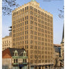 The "Historic Architecture of Pennsylvania" by Schiffer Publishing, Ltd. showcases a tall, tan art deco building with vertical lines, set among historic structures and a church in the Susquehanna Valley, viewed from a grassy lawn under a clear sky.