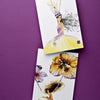 Celebrate contemporary stationery with "Today's Top Stationery Artists" by Schiffer Publishing, Ltd.—two illustrated postcards on purple, featuring a crowned woman in yellow and a girl flying with flower balloons, perfect for handwritten notes.
