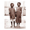 Two smiling children stand close, holding hands and gazing at each other. Captured in sepia, this evocative image from "True Africa" by Schiffer Publishing, Ltd. reflects the warmth found in Sub-Saharan African orphan photography.