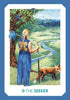 A blonde figure in butterfly-blue, holding a bundle, stands by a tree and river near mountains with a fox nearby. Inspired by the Gaian Tarot from Schiffer Publishing, Ltd., the card reads 0 THE SEEKER.