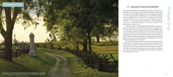A curved dirt path leads through grassy fields and tall trees to a stone monument, capturing the peaceful, historic beauty found in Maryland's Public Gardens & Parks by Schiffer Publishing, Ltd.