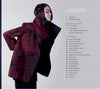 A woman with long dark hair models a textured, oversized red and black wearable fiber art jacket, standing in profile. Next to her is the table of contents for Artistry in Fiber, Vol. 3 by Schiffer Publishing, Ltd.