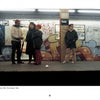 Five people stand on a subway platform in front of a graffiti-covered train, echoing early 1980s New York. Inspired by "New York Subway Graffiti" from Schiffer Publishing, Ltd., this scene captures the city’s vibrant street art culture.