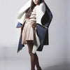 A woman poses in "Emerging Fashion Designers 5" by Schiffer Publishing, Ltd., wearing bold, sculptural looks that showcase new designer talent, styled against a plain studio background.